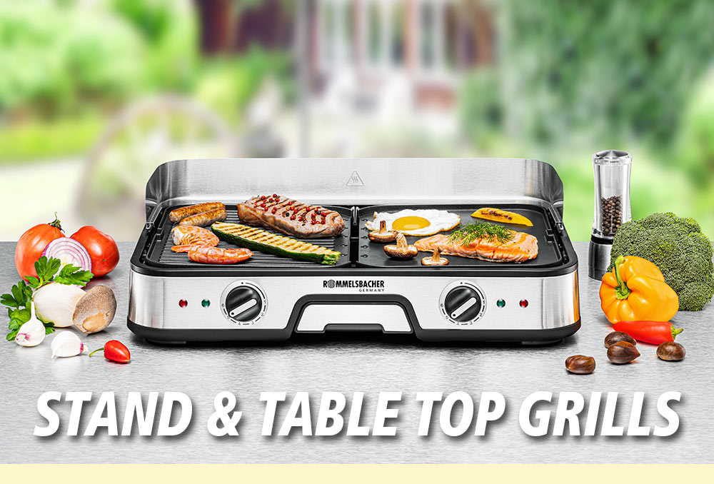 A silver stand and table top grill with two grill plates, topped with vegetables, fried eggs, and fish fillets. Surrounded by spices, broccoli, and bell pepper. The text in the image reads: “STAND & TABLE TOP GRILLS”.