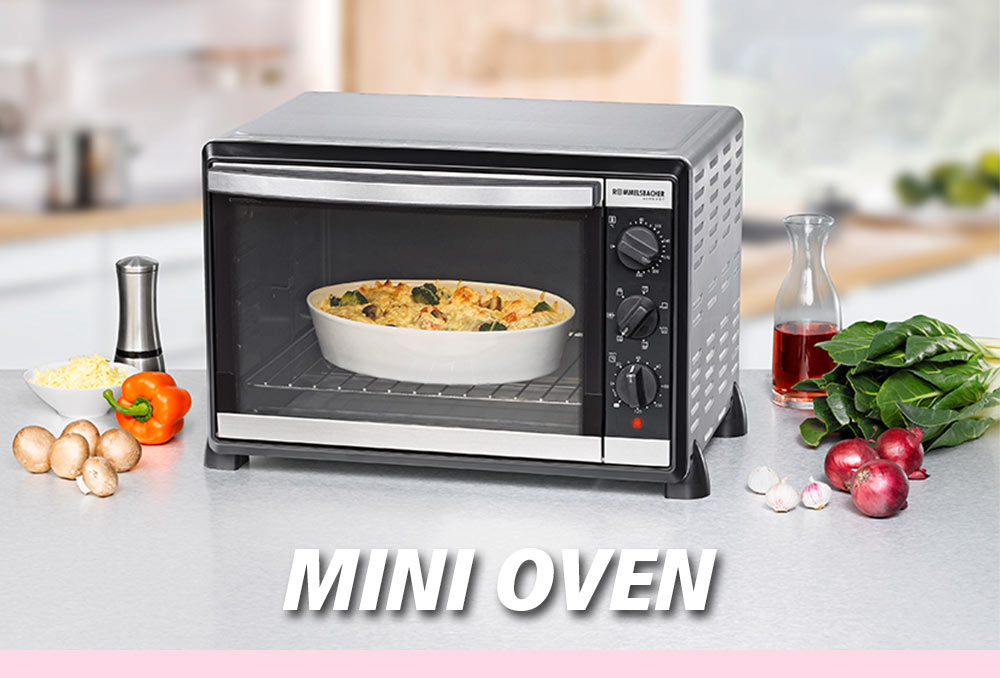 A silver mini oven with a black front. Inside is a casserole dish with a pasta meal. Surrounding it are vegetables such as bell pepper, mushrooms, onions, and spinach, as well as oil and spices. The text in the image reads: “MINI OVEN”.